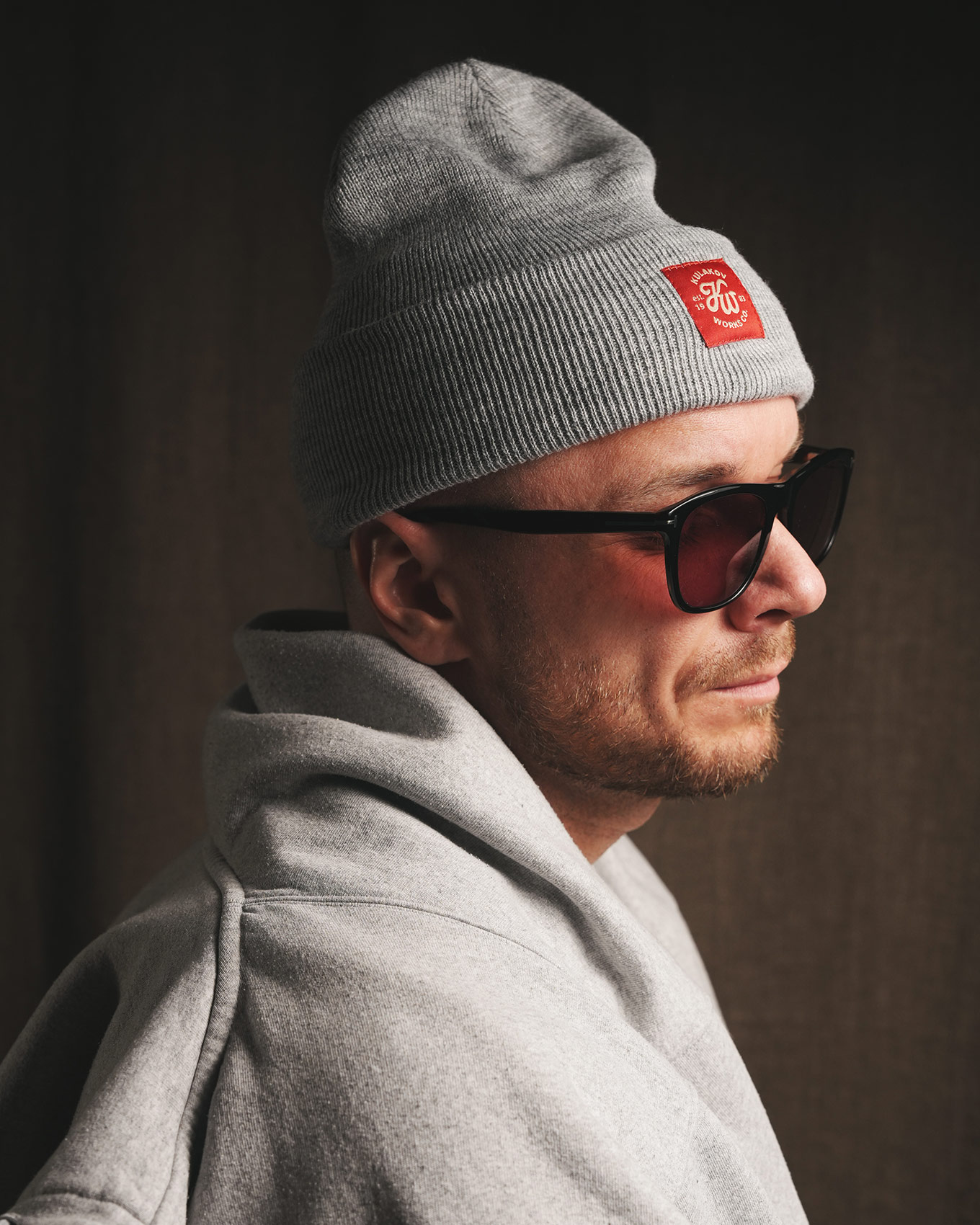 Тёплая серая вязаная шапка с красным логотипом в минималистичном стиле
